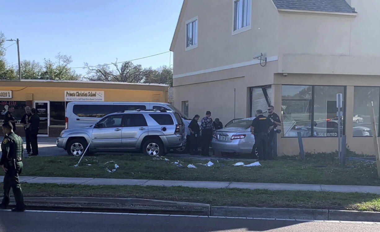 Law enforcement investigators examine a vehicle after it crashed into the side of a building in Winter Haven, Fla. Monday, Feb. 6, 2023. A man suspected in a mass shooting in central Florida last month was fatally shot by a police officer following a long chase and a carjacking, authorities said. The car driven by Alex Greene, 21, eventually crashed into a business in Winter Haven.