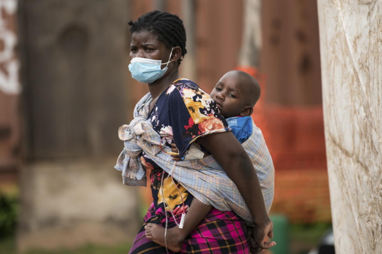 A woman carries her son, who has cholera, at Bwaila Hospital in Lilongwe central Malawi, Wednesday, Jan. 11, 2023. Malawi's health minister says the country's worst cholera outbreak in two decades has killed 750 people so far. The southern African country of 20 million people first reported the outbreak in March last year.