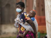 A woman carries her son, who has cholera, at Bwaila Hospital in Lilongwe central Malawi, Wednesday, Jan. 11, 2023. Malawi's health minister says the country's worst cholera outbreak in two decades has killed 750 people so far. The southern African country of 20 million people first reported the outbreak in March last year.