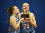 Mark Morris seniors Brooklyn Schlect and Isabella Merzoian (25) pose with the third-place trophy after winning the 2A district girls basketball tournament winner-to-state game at Ridgefield High School on Wednesday, Feb. 15, 2023.