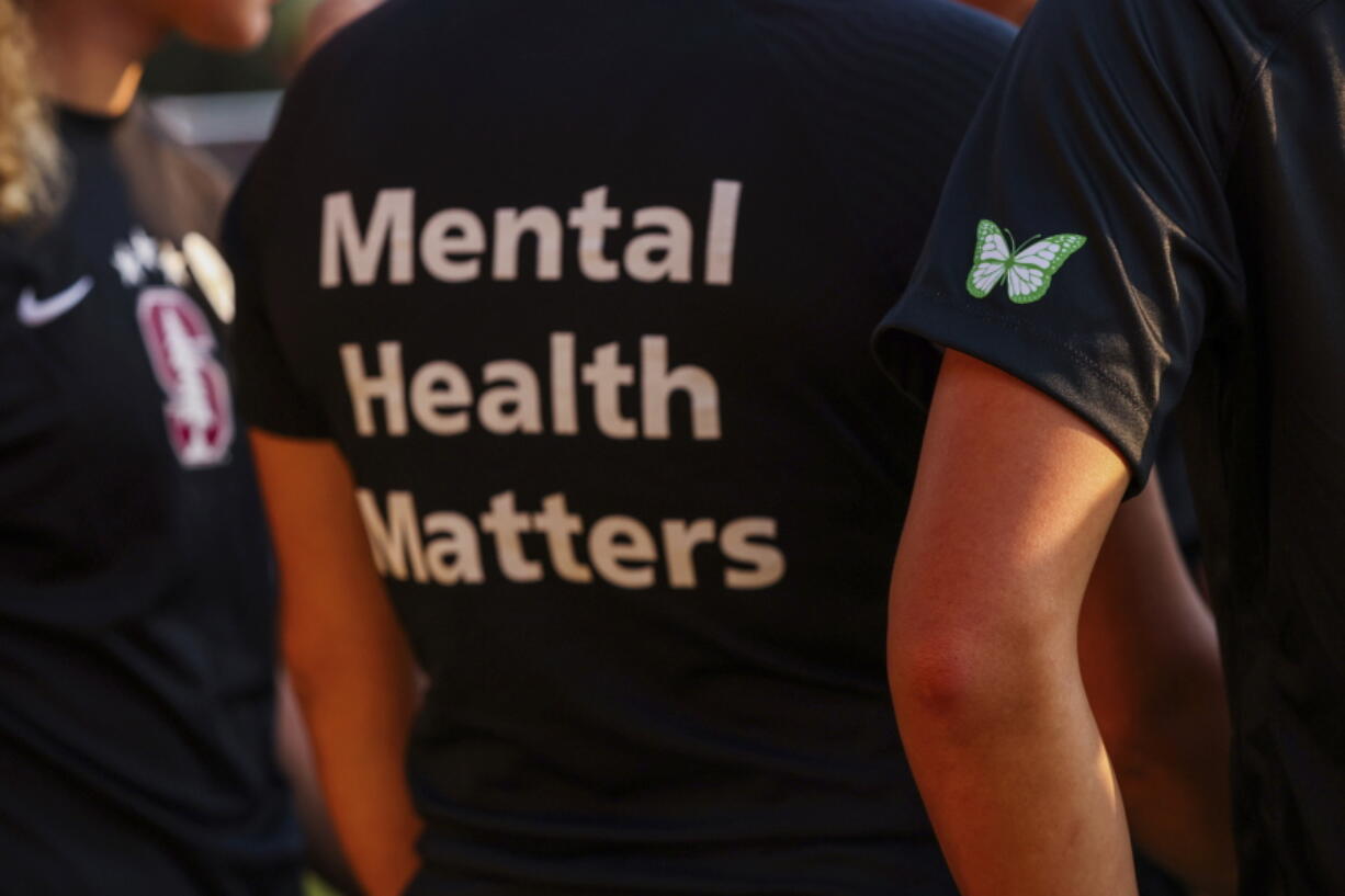 FILE - Stanford women's soccer team players wear warmup jerseys with "Mental Health Matters" on their backs as well as a butterfly patch on their sleeves to remember late goalie Katie Meyer, who died by suicide earlier in the year, before an NCAA college soccer match against UCLA, Oct. 14, 2022, in Stanford, Calif. The COVID-19 pandemic took an especially harsh toll on U.S. teen girls' mental health, with almost 60% reporting feelings of persistent sadness or hopelessness, according to a government survey released Monday, Feb. 13, 2023, that bolsters earlier data. (Yalonda M.