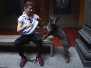 Nemiliz Gutierrez Arroyo sits Jan. 25 next to his Xoloitzcuintle breed dog named Mezcal, during a press conference about the Xoloitzcuintle in art, in Mexico City.