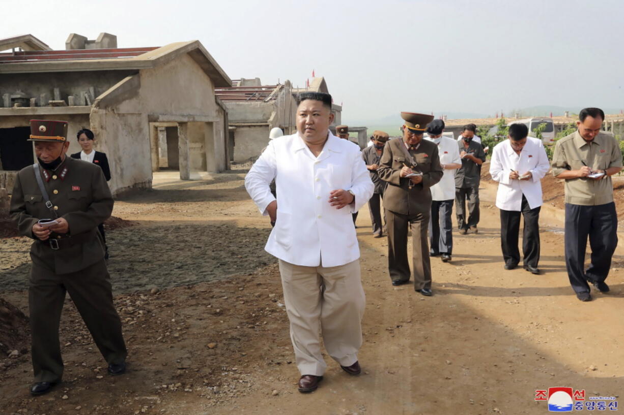 FILE - In this undated photo provided on July 23, 2020 by the North Korean government, North Korean leader Kim Jong Un, center, visits a new chicken farm being built in Hwangju County, North Korea. Independent journalists were not given access to cover the event depicted in this image distributed by the North Korean government.