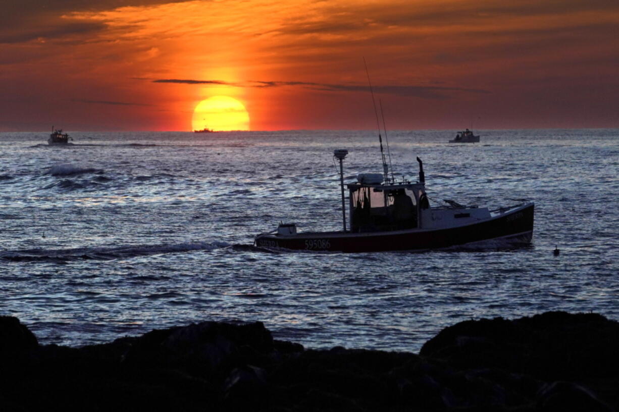 Lobster fishermen work at sunrise, Thursday, Sept. 8, 2022, off Kennebunkport, Maine. The waters off New England logged the second-warmest year in their recorded history in 2022, according to researchers. The Gulf of Maine, a body of water about the size of Indiana that touches Maine, New Hampshire, Massachusetts and Canada, is warming faster than the vast majority of the world's oceans. Scientists with Gulf of Maine Research Institute say 2022 fell short of setting a new high mark for hottest year in record by less than half a degree Fahrenheit. (AP Photo/Robert F.