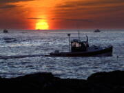 Lobster fishermen work at sunrise, Thursday, Sept. 8, 2022, off Kennebunkport, Maine. The waters off New England logged the second-warmest year in their recorded history in 2022, according to researchers. The Gulf of Maine, a body of water about the size of Indiana that touches Maine, New Hampshire, Massachusetts and Canada, is warming faster than the vast majority of the world's oceans. Scientists with Gulf of Maine Research Institute say 2022 fell short of setting a new high mark for hottest year in record by less than half a degree Fahrenheit. (AP Photo/Robert F.