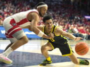 Arizona guard Kylan Boswell, left, and Oregon guard Will Richardson (0) reach for the ball during the first half of an NCAA college basketball game, Thursday, Feb. 2, 2023, in Tucson, Ariz.