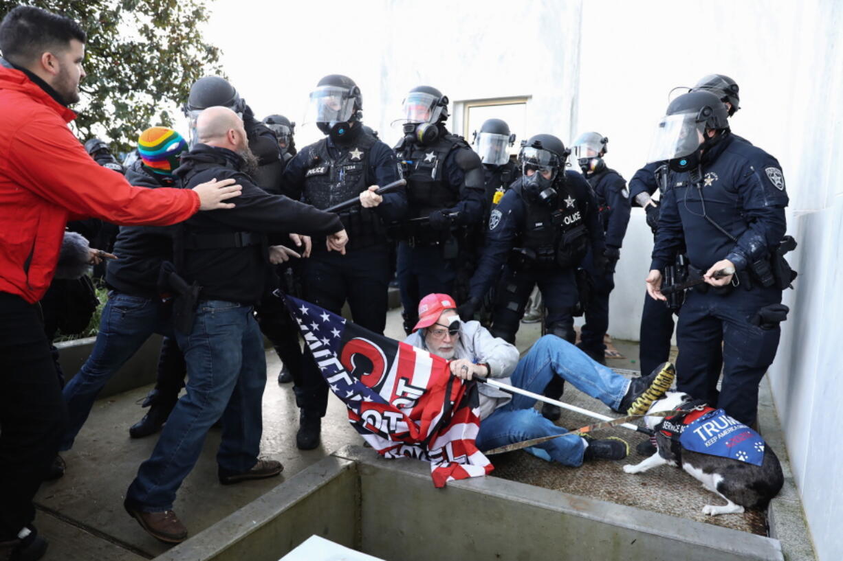 FILE - Law enforcement officers and protesters clash outside the Oregon State Capitol during a special session of the state legislature in Salem, Ore., on Dec. 21, 2020. Over the past decade, Oregon experienced the sixth-highest number of extremist incidents in the nation, despite being 27th in population, according to an Oregon Secretary of State report. Now, the state Legislature is considering a bill that, experts say, would create the nation's most comprehensive law against paramilitary activity.