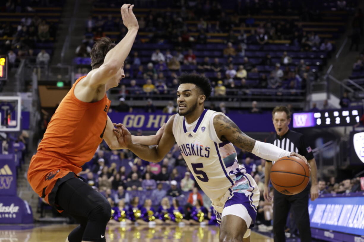 Washington guard Jamal Bey drives against Oregon State forward Dzmitry Ryuny during the first half of an NCAA collage basketball game, Saturday, Feb. 18, 2023, in Seattle.