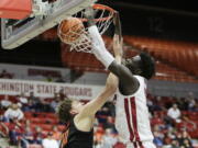 Washington State forward Mouhamed Gueye, right, dunks while defended by Oregon State forward Tyler Bilodeau during the first half of an NCAA college basketball game, Thursday, Feb. 16, 2023, in Pullman, Wash.