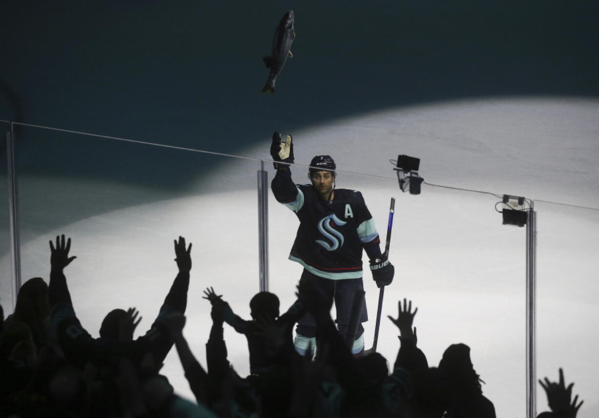 Seattle Kraken right wing Jordan Eberle (7) throws a stuffed salmon to fans as they celebrate the Kraken's 4-2 win against the Detroit Red Wings in an NHL hockey game Saturday, Feb. 18, 2023, in Seattle.