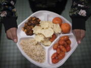 A 7th grader carries her plate which consists of three bean chili, rice, mandarins and cherry tomatoes and baked chips during her lunch break at a local public school, Saturday, Feb. 11, 2023, in the Brooklyn borough of New York. A 2010 federal law that boosted nutrition standards for school meals may have helped curb obesity among America'??s children _ even teenagers who can buy their own snacks, according to a study published Monday, Feb. 13, 2023, in the journal JAMA Pediatrics.