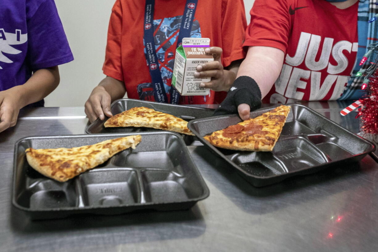 FILE - Second-grade students select their meals during lunch break in the cafeteria at an elementary school in Scottsdale, Ariz., Dec. 12, 2022. On Friday, Feb. 3, 2023, U.S. agriculture officials proposed new nutrition standards for school meals, including the first-ever limits on added sugars, with a focus on sweetened foods such as cereals, yogurt, flavored milk and breakfast pastries.