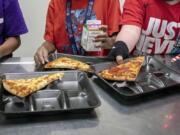 FILE - Second-grade students select their meals during lunch break in the cafeteria at an elementary school in Scottsdale, Ariz., Dec. 12, 2022. On Friday, Feb. 3, 2023, U.S. agriculture officials proposed new nutrition standards for school meals, including the first-ever limits on added sugars, with a focus on sweetened foods such as cereals, yogurt, flavored milk and breakfast pastries.