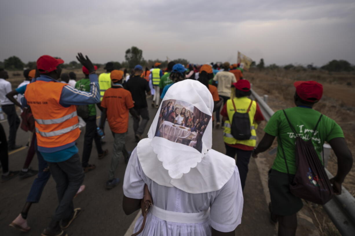 A sister wears headwear showing a picture of The Last Supper, as she and a group of the Catholic faithful from the town of Rumbek arrive after walking for more than a week to reach the capital for the visit of Pope Francis, in Juba, South Sudan Thursday, Feb. 2, 2023. Pope Francis is due to travel to South Sudan later this week on the second leg of a six-day trip that started in Congo, hoping to bring comfort and encouragement to two countries that have been riven by poverty, conflicts and what he calls a "colonialist mentality" that has exploited Africa for centuries.