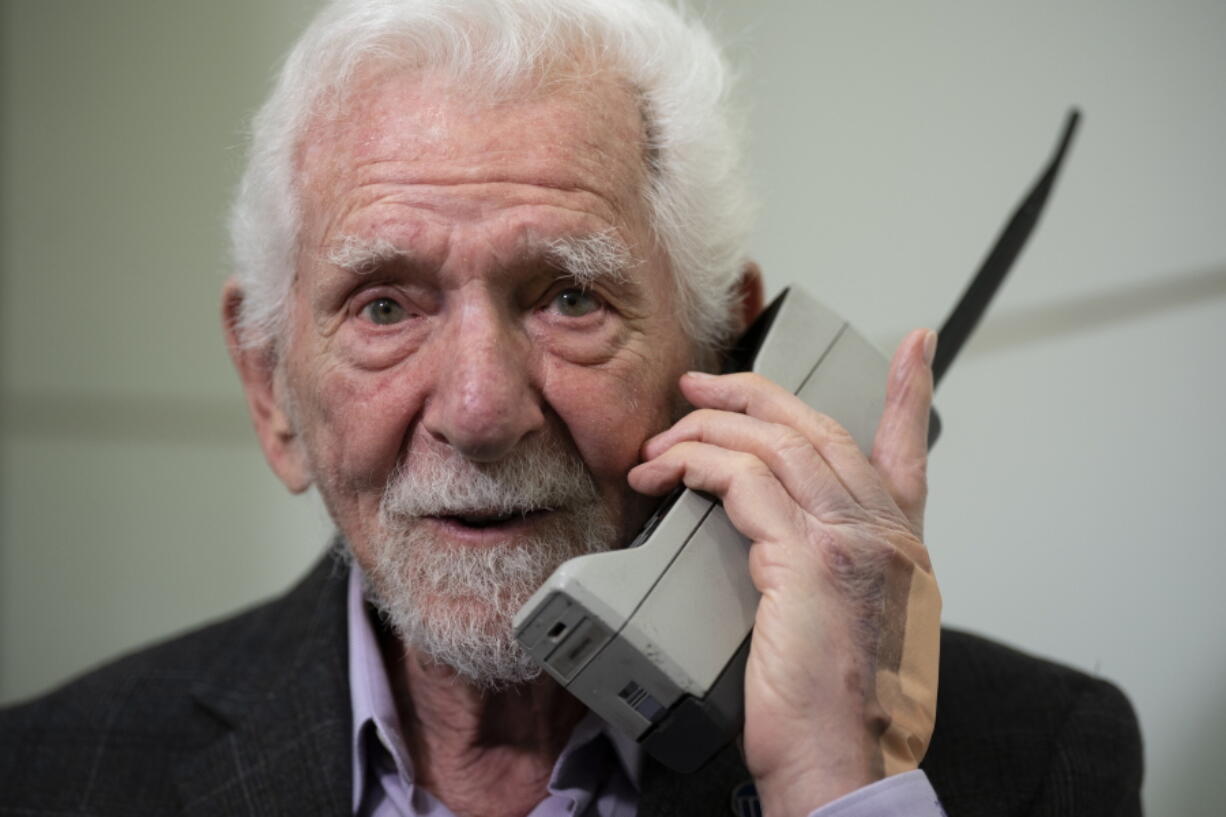 Marty Cooper, the inventor of first commercial mobile phone, poses for the press with a Motorola DynaTAC 8000x, during an interview with The Associated Press at the Mobile World Congress 2023 in Barcelona, Spain, Monday, Feb. 27, 2023. The four-day show kicks off Monday in a vast Barcelona conference center. It's the world's biggest and most influential meeting for the mobile tech industry.