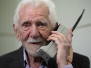 Marty Cooper, the inventor of first commercial mobile phone, poses for the press with a Motorola DynaTAC 8000x, during an interview with The Associated Press at the Mobile World Congress 2023 in Barcelona, Spain, Monday, Feb. 27, 2023. The four-day show kicks off Monday in a vast Barcelona conference center. It's the world's biggest and most influential meeting for the mobile tech industry.