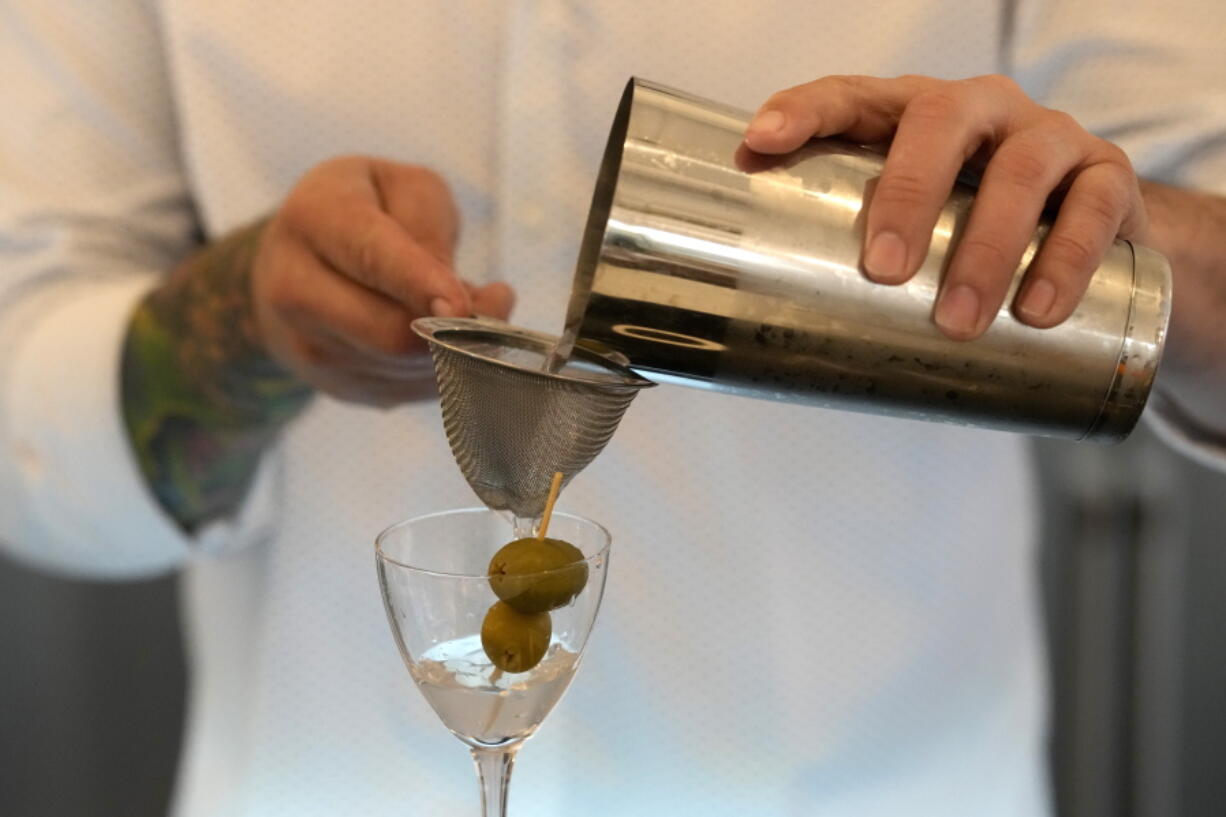 Bartender Brian McGee demonstrates how to make a Dirty Gin Martini with two olives at the Koval Distillery's tasting room Wednesday, Feb. 8, 2023, in Chicago. Spirits have surpassed beer for U.S. market share supremacy, led by a resurgent cocktail culture including the popularity of ready-to-drink concoctions according to the Distilled Spirits Council of the United States.