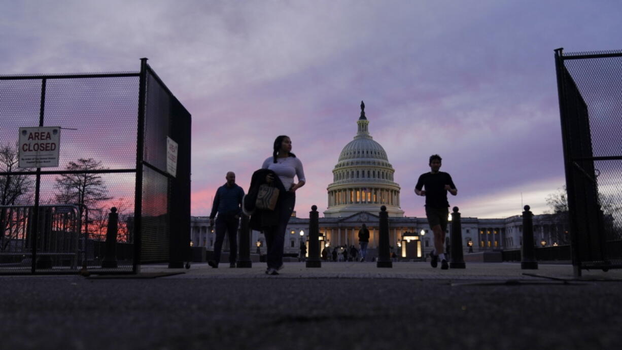 FILE - A perimeter fence around the U.S. Capitol is open for visitors to pass at sunset, Feb. 5, 2023, in Washington, ahead of the Tuesday evening State of the Union address. Biden on Tuesday night will stand before a joint session of Congress for the first time since voters in the midtem elections handed control of the House to Republicans.