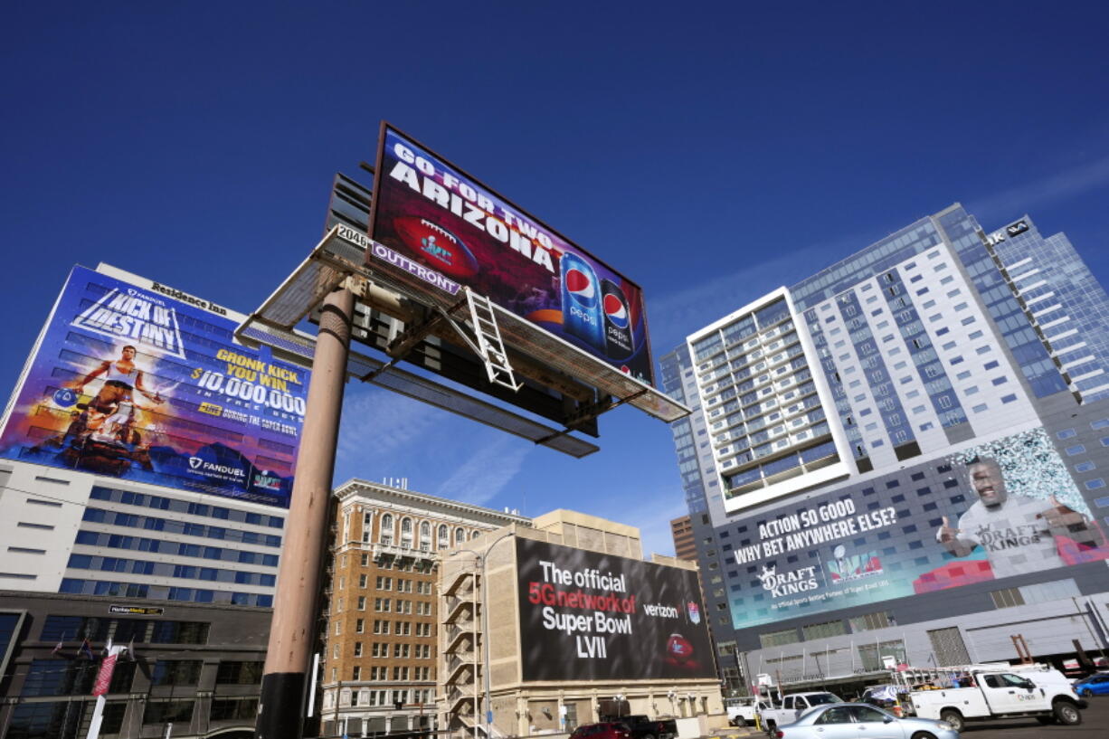 Large advertisements adorn buildings and electronic billboards leading up to the NFL Super Bowl LVII football game in Phoenix, Friday, Feb. 3, 2023. (AP Photo/Ross D.