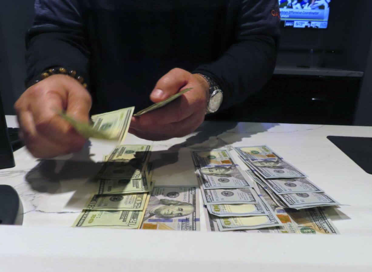 A sports book clerk counts money at the Ocean Casino Resort in Atlantic City, N.J., Monday, Feb. 6, 2023. On Feb. 7, 2023, the gambling industry's national trade group, the American Gaming Association, predicted that over 50 million American adults will bet a total of $16 billion on this year's Super Bowl, including legal bets with sports books, illegal ones with bookies, and casual bets among friends or relatives.