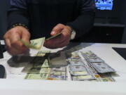 A sports book clerk counts money at the Ocean Casino Resort in Atlantic City, N.J., Monday, Feb. 6, 2023. On Feb. 7, 2023, the gambling industry's national trade group, the American Gaming Association, predicted that over 50 million American adults will bet a total of $16 billion on this year's Super Bowl, including legal bets with sports books, illegal ones with bookies, and casual bets among friends or relatives.