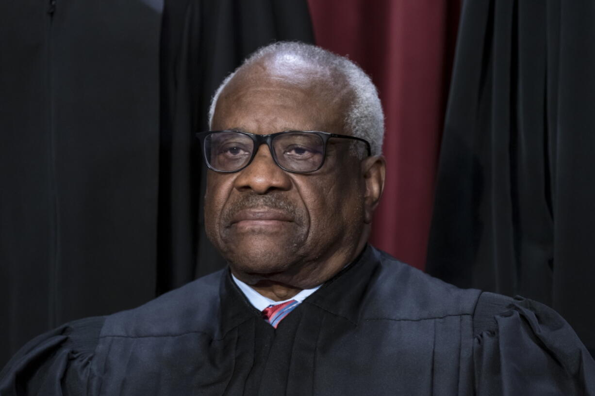 FILE - Associate Justice Clarence Thomas joins other members of the Supreme Court as they pose for a new group portrait, at the Supreme Court building in Washington, Oct. 7, 2022. The Supreme Court won't have far to look for a personal take on the "crushing weight" of student debt that underlies the Biden administration's college loan forgiveness plan. A legal challenge has reached the court and arguments are set for Tuesday. Thomas was in his mid-40s and in his third year on the nation's highest court when he paid off the last of his debt from his time at Yale Law School. (AP Photo/J.