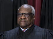 FILE - Associate Justice Clarence Thomas joins other members of the Supreme Court as they pose for a new group portrait, at the Supreme Court building in Washington, Oct. 7, 2022. The Supreme Court won't have far to look for a personal take on the "crushing weight" of student debt that underlies the Biden administration's college loan forgiveness plan. A legal challenge has reached the court and arguments are set for Tuesday. Thomas was in his mid-40s and in his third year on the nation's highest court when he paid off the last of his debt from his time at Yale Law School. (AP Photo/J.