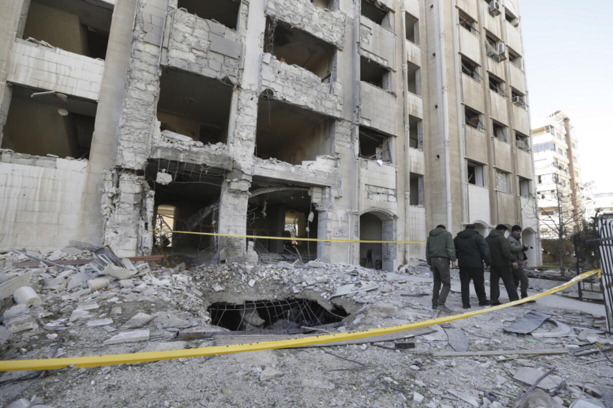 Syrian security officers inspect the damage in a residential neighborhood after an early morning Israeli airstrike in the capital city of Damascus, Syria, Sunday, Feb. 19, 2023. Syrian state news reported that Israeli airstrikes have targeted a residential neighborhood in central Damascus.