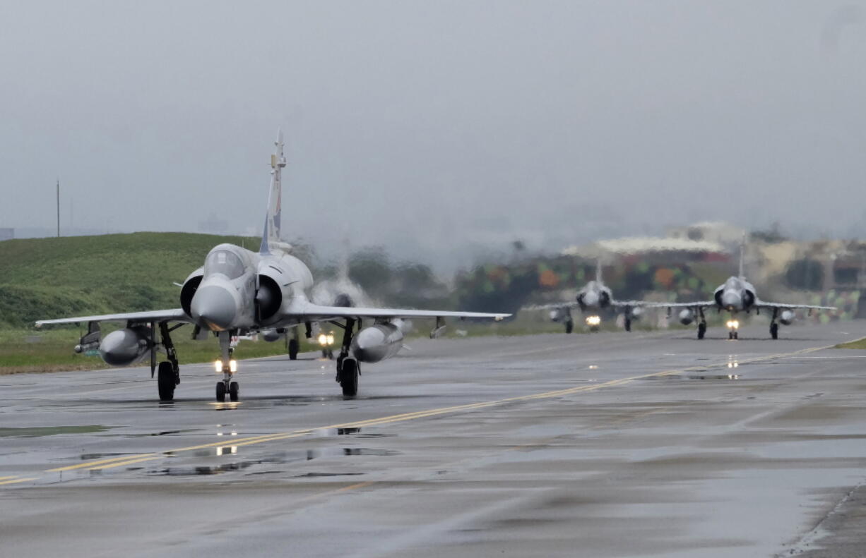 FILE - Taiwanese Mirage 2000 fighter jets taxi along a runway during a drill at an airbase in Hsinchu, Taiwan, Wednesday, Jan. 11, 2023. Taiwan scrambled fighter jets, put its navy on alert and activated missile systems Tuesday, Jan. 31, 2023, in response to nearby operations of 34 Chinese military aircraft and nine warships that are part Beijing's strategy to unsettle and intimidate the self-governing island democracy.