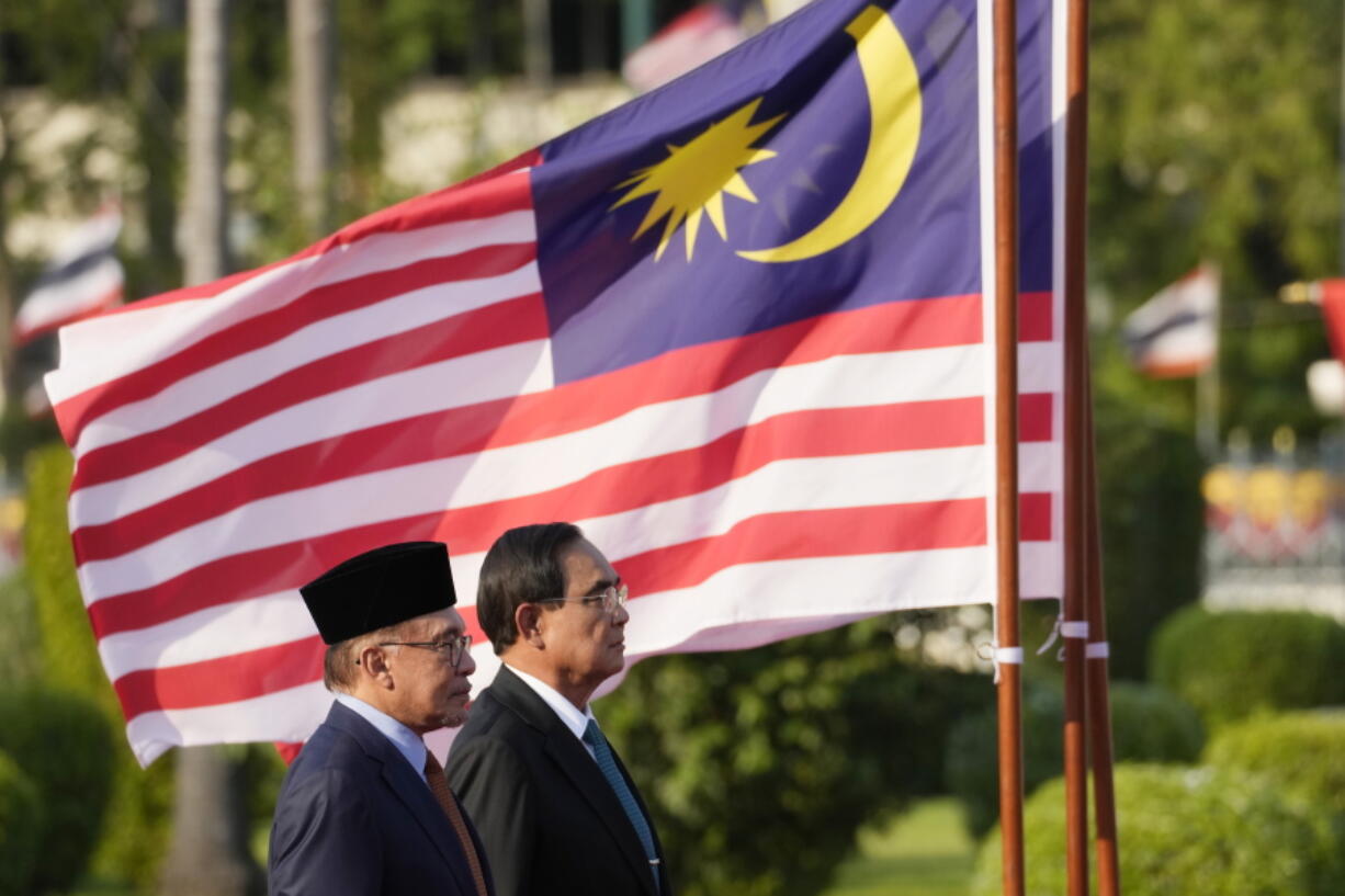 Malaysia's Prime Minister Anwar Ibrahim, left, and  Thailand's Prime Minister Prayuth Chan-ocha listen to their national anthems during a welcoming ceremony at the Government House in Bangkok, Thailand, Thursday, Feb. 9, 2023.