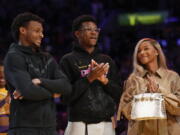 From left, Bronny James, Bryce James, and Savannah James applaud during a ceremony honoring Los Angeles Lakers forward LeBron James as the NBA's all-time leading scorer before an NBA game against the Milwaukee Bucks on Thursday, Feb. 9, 2023, in Los Angeles. James passed Kareem Abdul-Jabbar to earn the record during Tuesday's NBA game against the Oklahoma City Thunder. (AP Photo/Mark J.