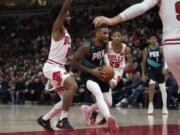 Portland Trail Blazers guard Damian Lillard, center, gets by Chicago Bulls guard Coby White, left, during the first half of an NBA basketball game Saturday, Feb. 4, 2023, in Chicago.