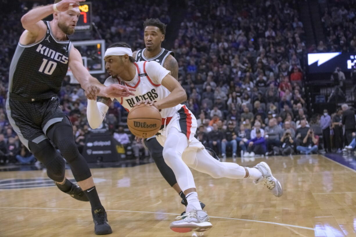 Portland Trail Blazers guard Keon Johnson drives to the basket past Sacramento Kings forward Domantas Sabonis (10) during the first quarter of an NBA basketball game in Sacramento, Calif., Thursday, Feb. 23, 2023.