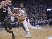 Portland Trail Blazers guard Keon Johnson drives to the basket past Sacramento Kings forward Domantas Sabonis (10) during the first quarter of an NBA basketball game in Sacramento, Calif., Thursday, Feb. 23, 2023.