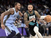 Portland Trail Blazers guard Damian Lillard (0) handles the ball against Memphis Grizzlies forward Xavier Tillman (2) in the first half of an NBA basketball game Wednesday, Feb. 1, 2023, in Memphis, Tenn.