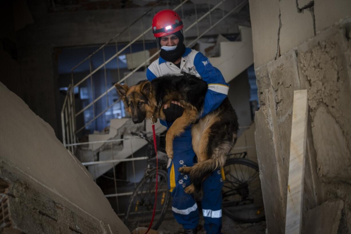 Mehmet Gurkan, a member of the Turkish animal rights group HAYTAP, rescues a dog Sunday that was trapped for seven days inside a house affected by the earthquake in Antakya, southeastern Turkey.