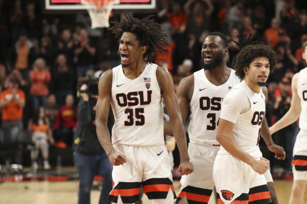 Oregon State's Glenn Taylor Jr., left, Rodrigue Andela, center, and Jordan Pope, right, celebrate after their win over Southern California in an NCAA college basketball game in Corvallis, Ore., Saturday, Feb. 11, 2023.