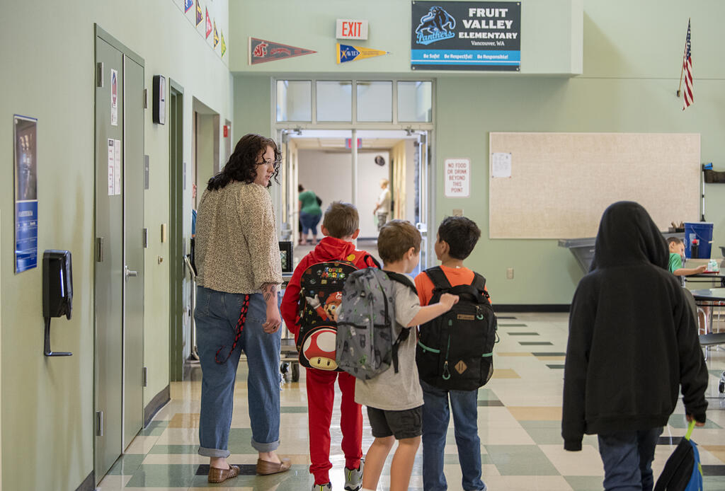 Paraeducator Zayla Wollen walks with students on the first day of school at Fruit Valley Elementary School on  Aug. 30, 2022.