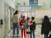 Paraeducator Zayla Wollen walks with students on the first day of school at Fruit Valley Elementary School on  Aug. 30, 2022.