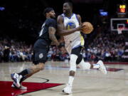 Golden State Warriors forward Draymond Green drives to the basket past Portland Trail Blazers guard Gary Payton II during the first half of an NBA basketball game in Portland, Ore., Wednesday, Feb. 8, 2023.