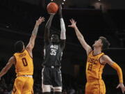 Washington State forward Mouhamed Gueye, center, shoots as Southern California forward Kobe Johnson, left, and guard Drew Peterson defend during the first half of an NCAA college basketball game Thursday, Feb. 2, 2023, in Los Angeles. (AP Photo/Mark J.