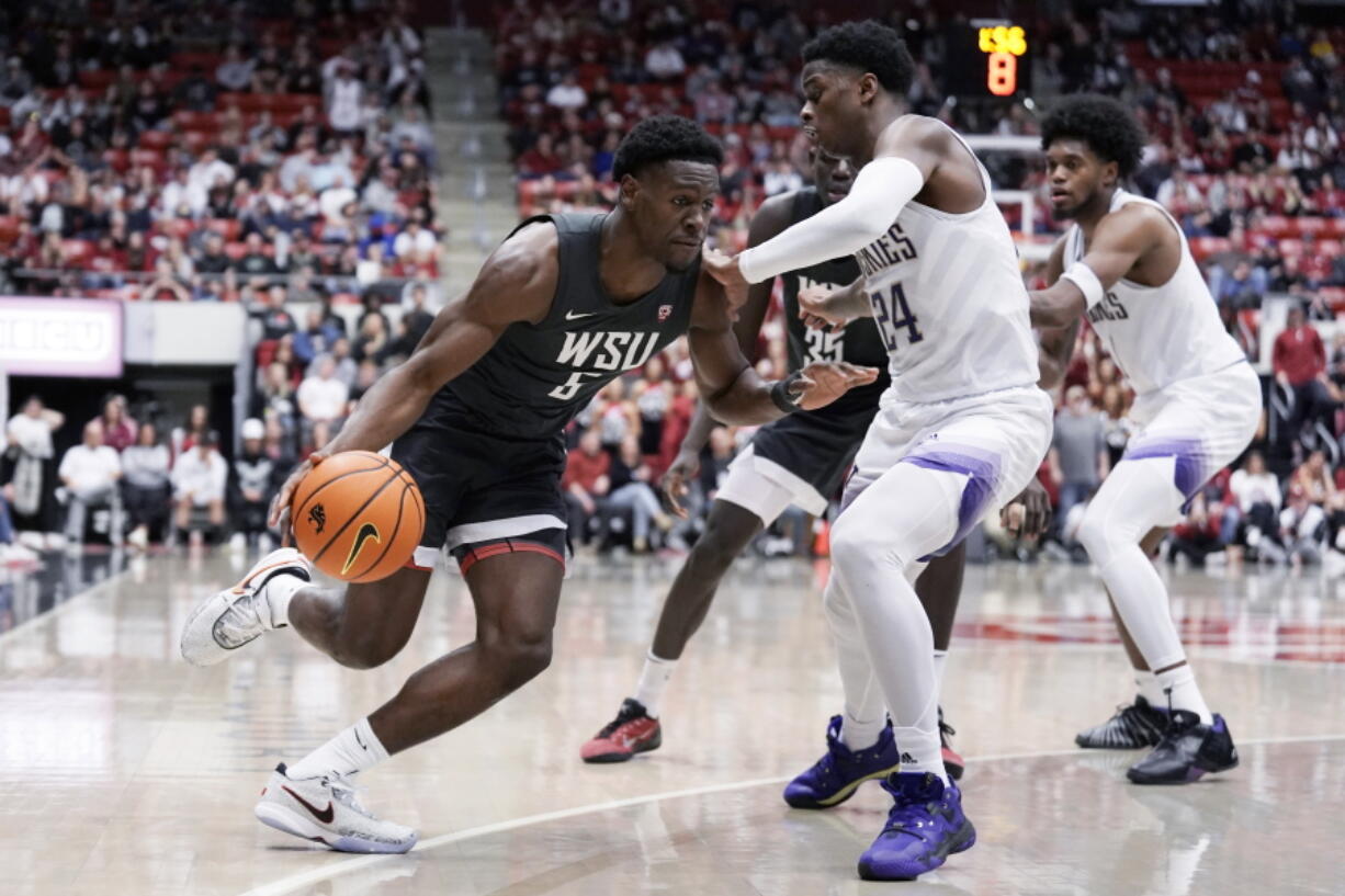 Washington State guard TJ Bamba (5) drives against Washington guard Noah Williams (24) during the second half of an NCAA college basketball game Saturday, Feb. 11, 2023, in Pullman, Wash.