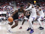 Washington State guard TJ Bamba (5) drives against Washington guard Noah Williams (24) during the second half of an NCAA college basketball game Saturday, Feb. 11, 2023, in Pullman, Wash.