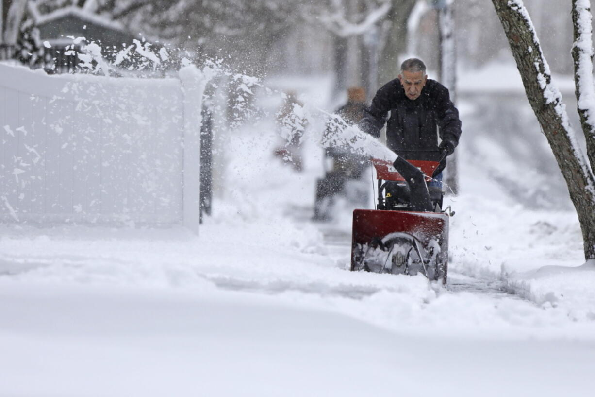 Don Perry uses a snowblower to clear the snow from the sidewalk in front of his home in New Bedford, Mass., on Tuesday, Feb. 28, 2023 as residents dig out of the only snow storm of the season.  Heavy snow bookended the United States on Tuesday, with a late-season storm bringing a messy morning commute to the Northeast and California residents digging out, or in some cases simply stranded, after yet another storm.