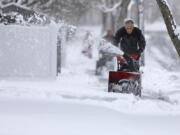 Don Perry uses a snowblower to clear the snow from the sidewalk in front of his home in New Bedford, Mass., on Tuesday, Feb. 28, 2023 as residents dig out of the only snow storm of the season.  Heavy snow bookended the United States on Tuesday, with a late-season storm bringing a messy morning commute to the Northeast and California residents digging out, or in some cases simply stranded, after yet another storm.