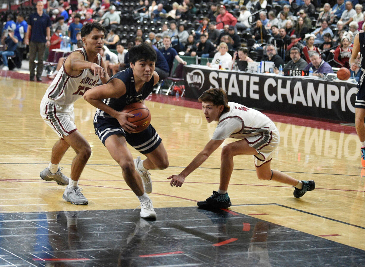 Seton Catholic’s Lance Lee drives past two Toppenish defenders during a Class 1A boys basketball state tournament game on Wednesday, March 1, 2023 in Yakima.