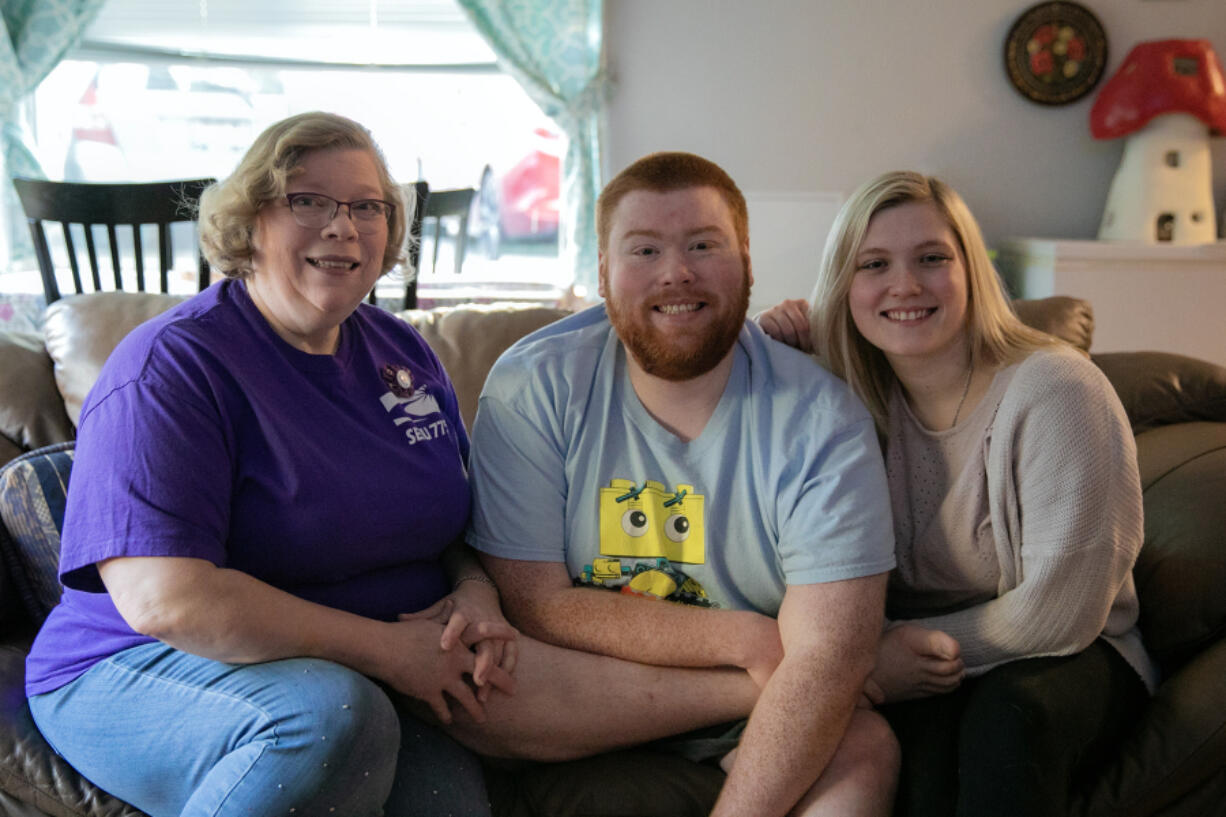 Mae Hochstetler, left, sits with her twin children Josh and Joy Hochstetler, both 25, at her home where she lives with Josh on Feb. 24, in Lynnwood.
