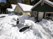 Kadyn Wheat, 14, on Tuesday shovels snow to free the family car that is entombed in the driveway after successive snow storms paralyzed the San Bernardino Mountain community.