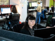 Crisis intervention hotline expansion volunteer Victoria Grove works at her desk in Crisis Connections, which manages the regional crisis hotline and 988 crisis number, on Wednesday, March 9, 2023, in Belltown.