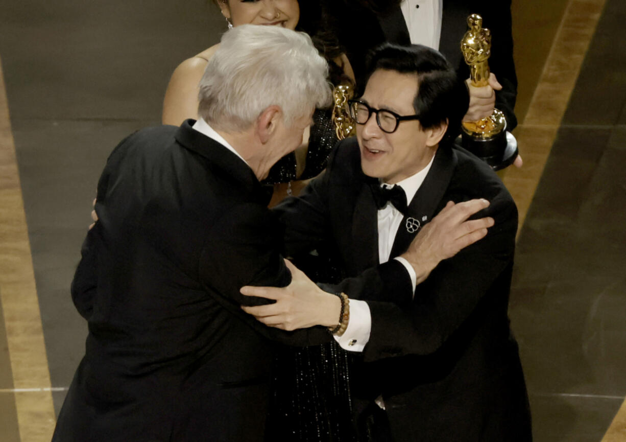 Ke Huy Quan, right, accepts the award for Best Picture for "Everything Everywhere All at Once" from Harrison Ford onstage during the 95th Annual Academy Awards at Dolby Theatre on March 12, 2023, in Hollywood, California.